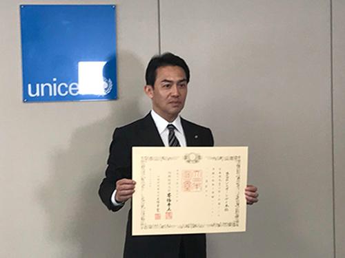 内閣府から紫綬褒章を授章。褒状を受け取った佐藤健社長